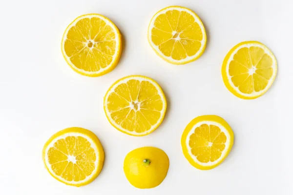 Lemon slices randomly lie on the light surface of the table. — Stock Photo, Image