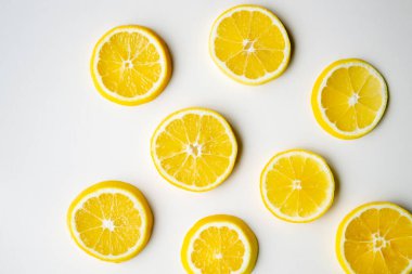 Limon dilimleri masanın ışık yüzeyinde rastgele yatar..