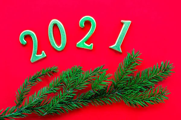 Ouro número 2021 e árvore de Natal ramo no fundo vermelho. — Fotografia de Stock
