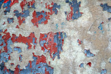 Close-up old colored concrete wall. Weathered wall with chipped blue and red paint. cracked texture, abstract background.