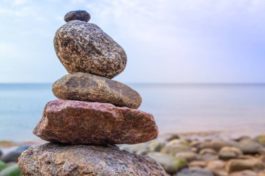 Pebble beach, beautiful view. Stones pyramid on the seashore at sunset. Rest and seaside vacation. Concept of balanced life, harmony and relax.