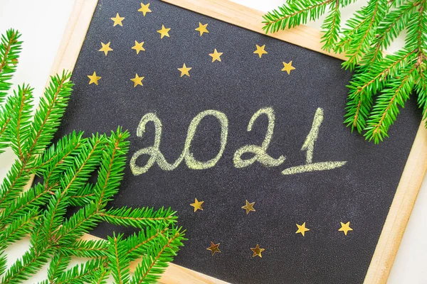 新年的概念 2021年粉笔手写在黑板上 金色的星星 圣诞树绿色枝干的框架 — 图库照片