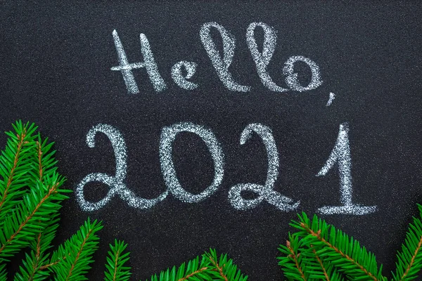 新年的概念 粉笔手写题词2021年你好 在黑板上 把圣诞树的绿枝做成一个圆形的框架 平躺在床上 — 图库照片