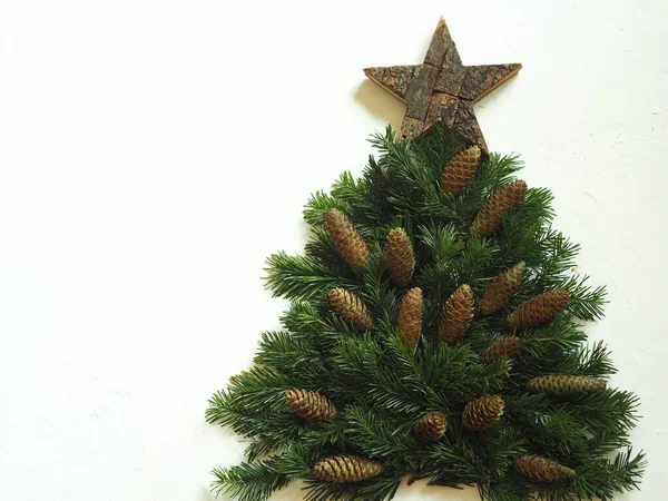 Weihnachtsbaum Aus Tannenzweigen Mit Einem Hölzernen Stern Und Tannenzapfen Auf — Stockfoto