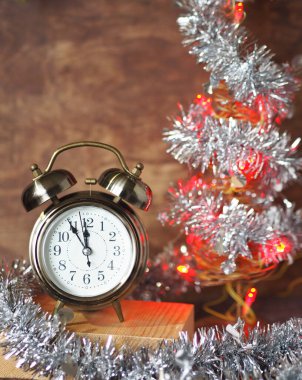 Ahşap arka plan, saat ve yılbaşı ışıkları ile dekoratif Noel ağacı. Selamlar Noel arkaplanı.