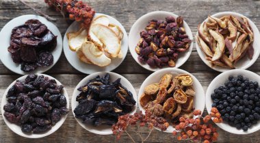 Ahşap bir arka planda çeşitli kurumuş meyvelerle dolu kaseler. Kurumuş meyvelerin ev yapımı..