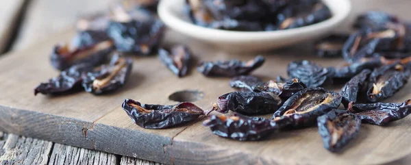 Dried plums in a bowl on a wooden background.Home preparation of dried fruits.