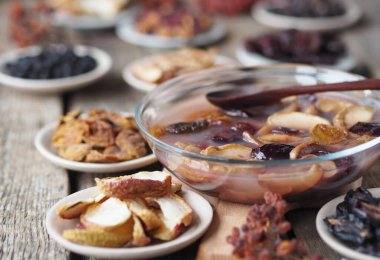 Kurumuş meyvelerle çevrili meyve jölesi. Ahşap bir arka planda, tabakta kurumuş meyveler. Sağlıklı ev yapımı tatlı. Kurutulmuş meyvelerin ev yapımı.