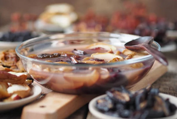 Fruit jelly with dried fruits surrounded by dried fruits on plates on a wooden background. Healthy natural homemade dessert. Home preparation of dried fruits.