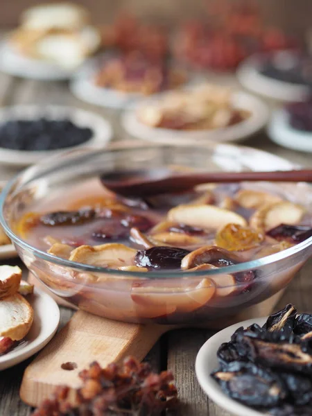 Fruit jelly with dried fruits surrounded by dried fruits on plates on a wooden background. Healthy natural homemade dessert. Home preparation of dried fruits.