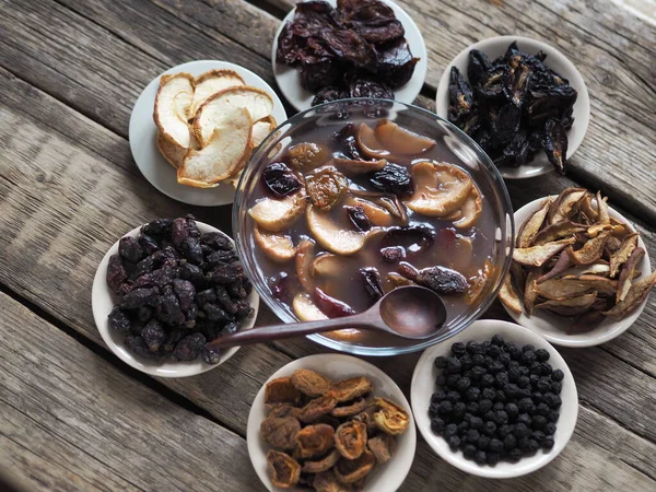 Healthy natural dessert fruit jelly with dried fruits surrounded by dried fruits on plates on a wooden background.Home preparation of dried fruits.