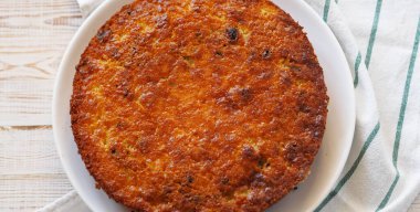 Ahşap bir arka planda, peçeteli yuvarlak irmik turta. Ev yapımı hamur işleri. Yukarıdan görüntüle.