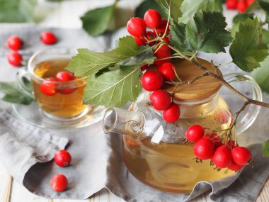 Taze toplanmış böğürtlenlerden yapılmış bir fincan sıcak Hawthorn çayı. Kırsal ahşap arka planda kalp sağlığı için bitkisel ilaç.