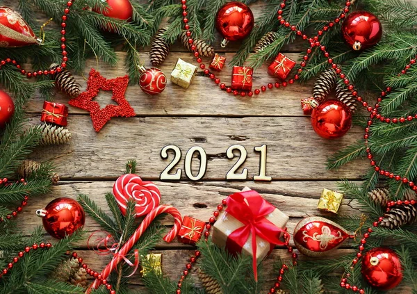 2021番のテキストの場所 クリスマスと新年の休日のための挨拶カード 木のヴィンテージの背景にモミの枝と赤いクリスマスの装飾 — ストック写真