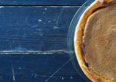 Ev yemeği. Turuncu kabaklı turta. Koyu ahşap arka planda doğal vejetaryen tatlısı. Üst görünüm, düz biçim.
