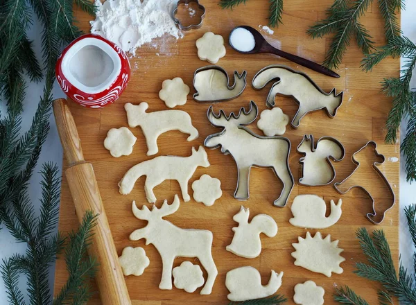 Robiąc Świąteczne Ciasteczka Zwierzęce Ciasteczka Stole Kuchennym Wśród Gałązek Jodłowych — Zdjęcie stockowe