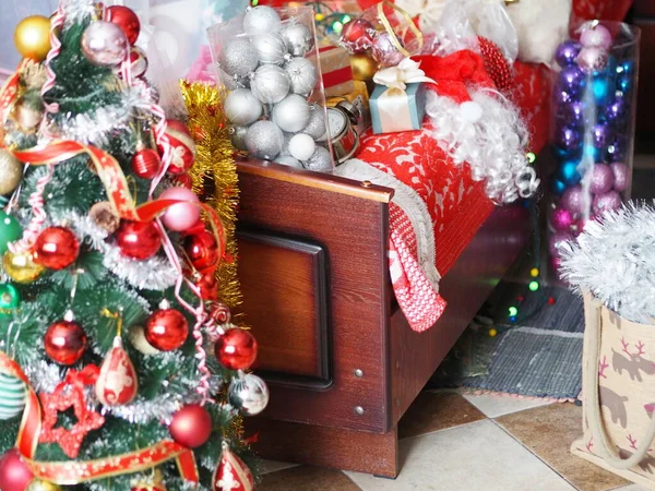Decorazioni natalizie e di Capodanno. Alla vigilia di Natale, rimuovere e disfare la borsa contenente regali, giocattoli, rami di abete rosso verde, fili di lame e coni di abete Decorare il vostro albero e la casa. Il offuscato — Foto Stock