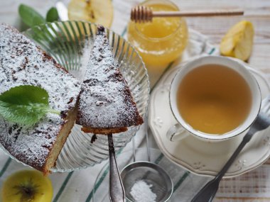 Hafif ahşap bir masanın üzerine çay serpiştirilmiş çikolatalı kek. Ev yapımı sağlıklı yiyecekler..