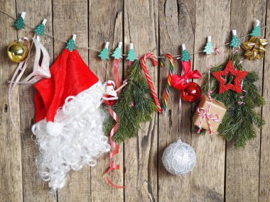 Noel arifesinde Noel Baba 'nın şapkası, ladin dalları ve yeni yıl süsleri mandallı bir iple asılır. Noel Baba tatil için hazırlanıyor..