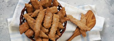 Mutfak peçetesiyle birlikte gri arka planda pişmiş taze kurabiyeli doğal hasır tabak. Ev yapımı taze kurabiyeli yemek arkaplanı..