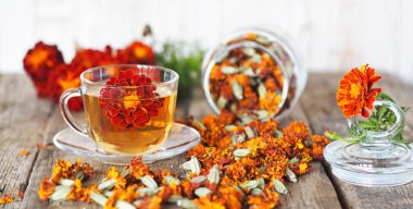 Kadife çiçeklerinin kullanışlı özellikleri. Çiçek kullanımı Çernobrovtsy ya da halk alternatif tıbbında Mary 's Gold. Kurumuş çiçekli kadife çiçekleri, tahta bir arka planda kavanozda..