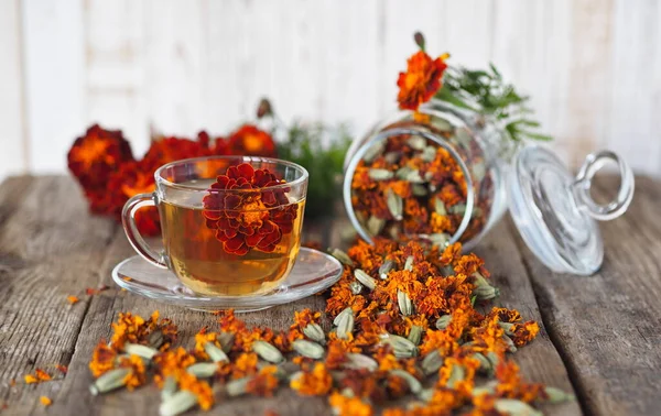 Kadife çiçeklerinin kullanışlı özellikleri. Çiçek kullanımı Çernobrovtsy ya da halk alternatif tıbbında Mary 's Gold. Kurumuş çiçekli kadife çiçekleri, tahta bir arka planda kavanozda..