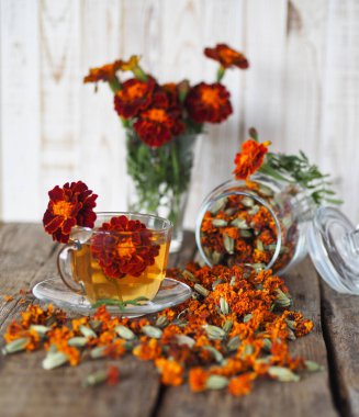 Kadife çiçeklerinin kullanışlı özellikleri. Çiçek kullanımı Çernobrovtsy ya da halk alternatif tıbbında Mary 's Gold. Kurumuş çiçekli kadife çiçekleri, tahta bir arka planda kavanozda..