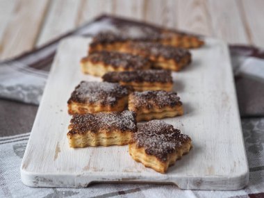 Tereyağlı bisküviler üzerine tarçın ve şeker serpiştirilmiş mutfak tahtası. Ev yemeği..