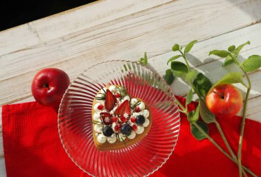 Sevgililer günü için ev yapımı sevgililer günü kurabiyelerinin üst görüntüsü beyaz bir tabakta üzerinde bir tutam nane ile kırmızı bir peçete..