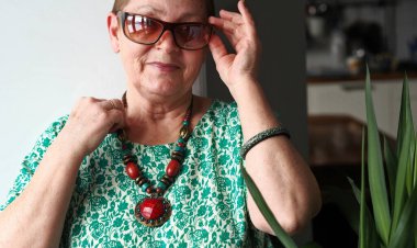 Tayland elbisesi giyen, doğal malzemelerden yapılmış geleneksel Tayland madalyonu takan son sınıf Avrupalı kadın.