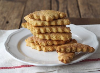 Tahta arka planda oyulmuş kenarlı ev yapımı ballı kurabiyeler. Sağlıklı doğal yiyecek..