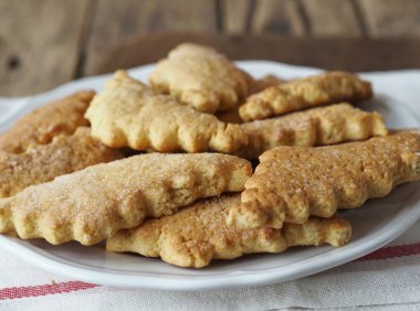 Tahta arka planda oyulmuş kenarlı ev yapımı ballı kurabiyeler. Sağlıklı doğal yiyecek..