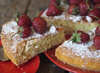 Taze pişmiş, üzerine pudra şekeri serpiştirilmiş, ahşap zemin üzerinde çilek ve çilekle bisküvi serpiştirilmiş. Şekerleme arkaplanı.