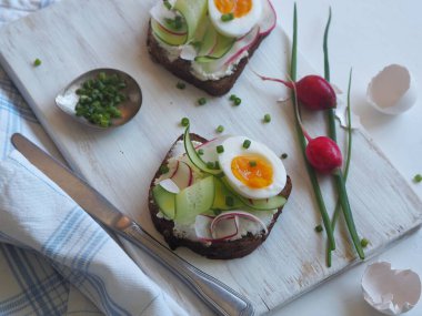 Yukarıdan bak. Hafif arka plan. Vejetaryen salatalıklı sandviç ve turplu mutfak lambası. Sağlıklı doğal yaz yemekleri..