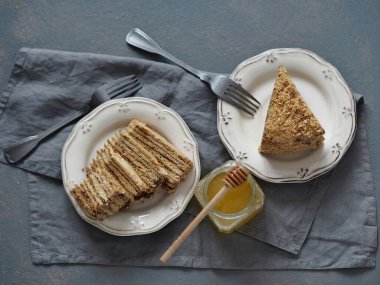 Gri arka planda bal olan gri bir peçeteye iki parça ballı puf kek. Gıda arkaplanı.