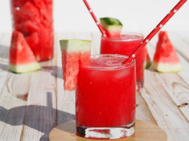 Parlak yaz yemekleri ve karpuzlar. Beyaz ahşap arka planda buzlu taze kırmızı karpuz içeceği..