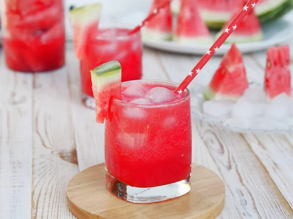 スイカと明るい夏の食品の背景 白木の背景に氷と新鮮な赤スイカの飲み物のガラス — ストック写真