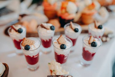 Düğün menüsü. Beyaz bir masa örtüsü ve ahşap bir kulübede yaban mersini ve waffle külahlı tatlı çilekli düğün tatlısı servis ediyorum..