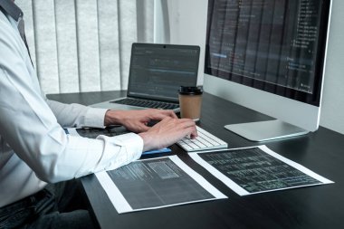 Bilişim ofisinde yazılım javascript bilgisayarı üzerinde çalışan genç programcı, problem çözümü bulmak için kodlar ve veri kodu web sitesi ve kodlama veritabanı teknolojileri yazıyor.