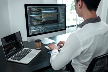 Bilişim ofisinde yazılım javascript bilgisayarı üzerinde çalışan genç programcı, problem çözümü bulmak için kodlar ve veri kodu web sitesi ve kodlama veritabanı teknolojileri yazıyor.