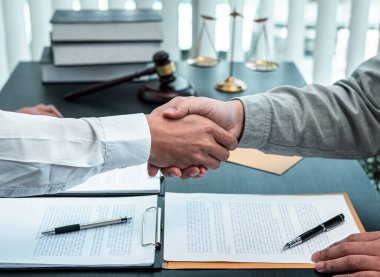 Erkek avukat, iyi bir müzakere işbirliği toplantısı sonrasında müvekkille tokalaşıyor..