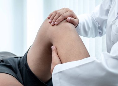 Atletizm hastasının yaralı bacağını tedavi eden fizyoterapist, klinikte rehabilitasyon tedavisi gören doktor..