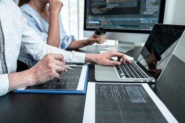 IT ofisindeki yazılım javascript bilgisayarı üzerinde çalışan programcı ekibi, sorunlara çözüm bulmak için kodlar ve veri kodu web sitesi ve kodlama veritabanı teknolojileri yazıyorlar..
