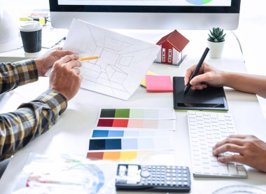 Modern ofiste çalışan grafik tablet ve renk örnekleri üzerine çizim yapan genç İç mimari çalışma evi projesinin takım tasarımı, yaratıcı ilham ve hayal gücü.