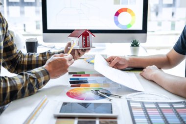 Modern ofiste çalışan grafik tablet ve renk örnekleri üzerine çizim yapan genç İç mimari çalışma evi projesinin takım tasarımı, yaratıcı ilham ve hayal gücü.