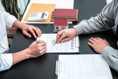 Emlakçı ev kredisi sunuyor ve kira kontratı imzaladıktan sonra onaylanmış emlak başvuru formu sözleşmesi ile müşteriye anahtar veriyor.