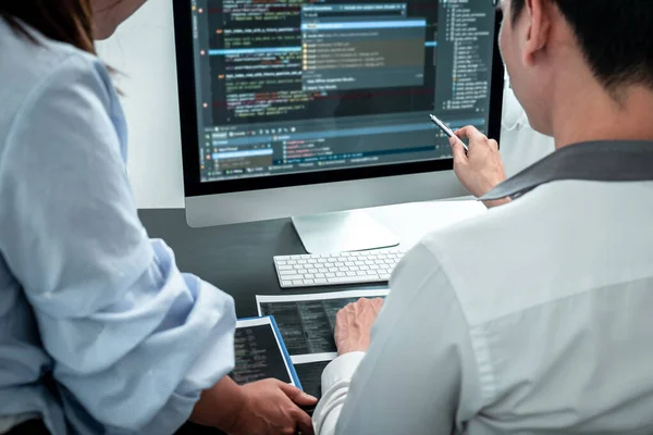 Geliştirme Ekibi programlama yazılımı bilgisayarı üzerinde çalışıyor, web sitesi ve geliştirme veritabanı teknolojisi yazıyor.