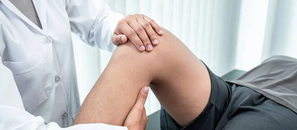 Atletizm hastasının yaralı bacağını tedavi eden fizyoterapist, klinikte rehabilitasyon tedavisi gören doktor..