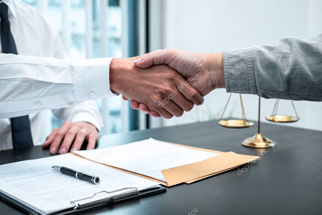 Male lawyer shaking hands with client after good deal negotiation cooperation meeting in courtroom.