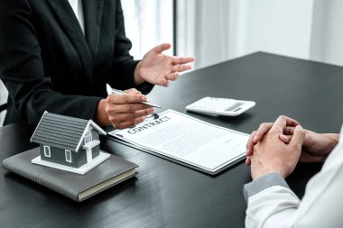 Satış temsilcisi, kiralık ev sigortası ve onaylanmış emlak formu sözleşmesi imzalama kararı için müşteriye ev kredisi sunuyor..